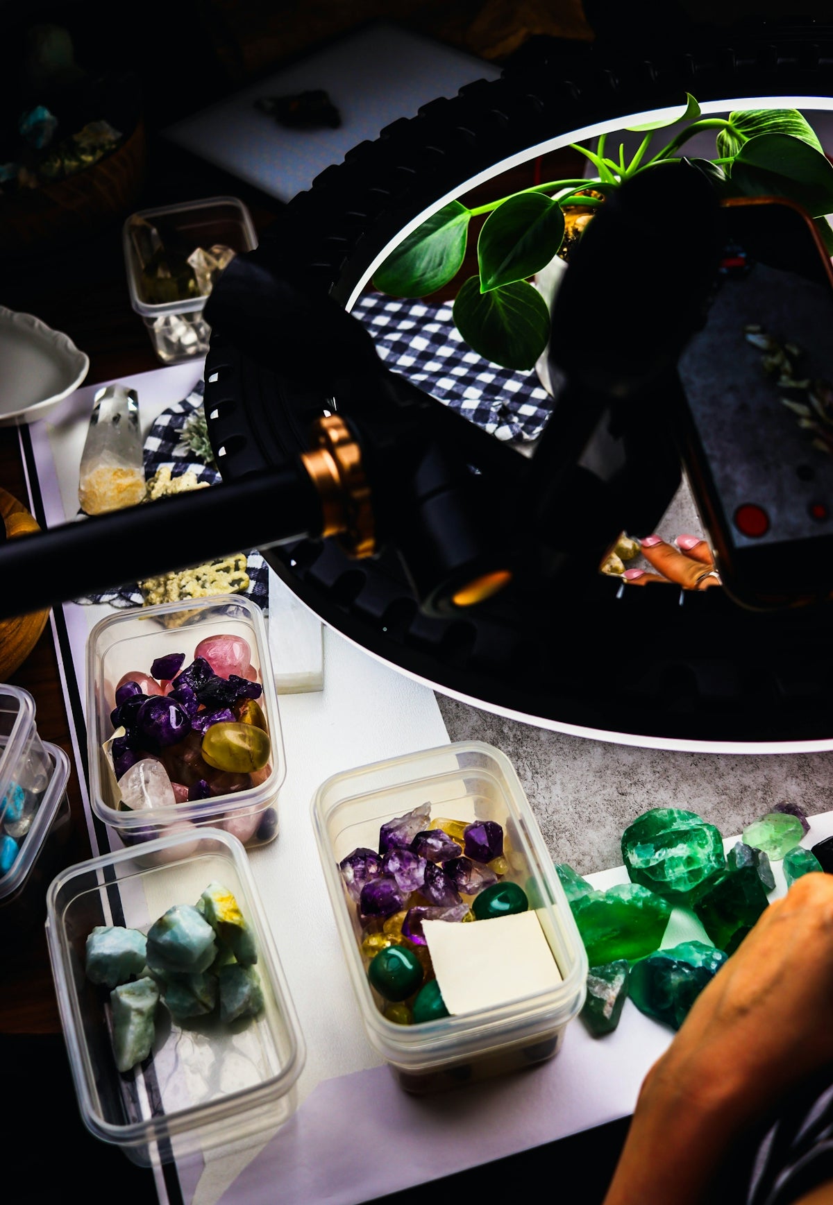 Hand sorting colorful polished crystals and gemstones in containers
